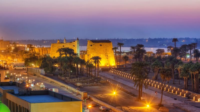 Luxor Temple illuminated at dusk in Egypt.