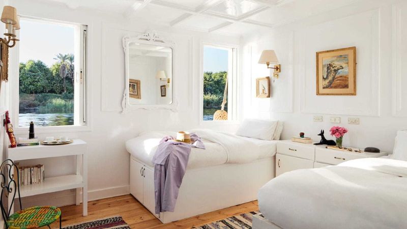 Sunny bedroom with a view of greenery outside the window.