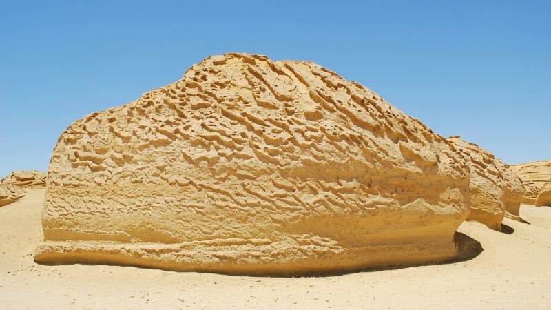 Stunning view of the White Desert in Egypt, featuring unique chalk rock formations resembling mushrooms and natural sculptures under a clear sky
