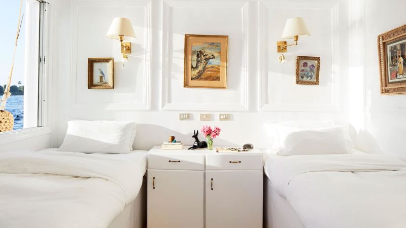 Bright white bedroom interior with twin beds and elegant wall decorations