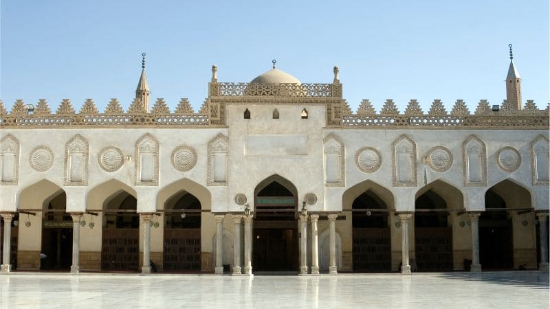 Front view of a mosque with arched doorways and a dome.