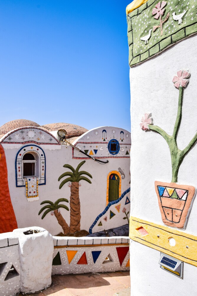 A traditional Nubian homestead with colorful artistic decorations and clay brick architecture.