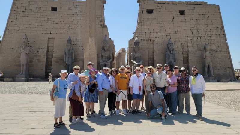 A group of tourists posing in front of Luxor Temple in Egypt