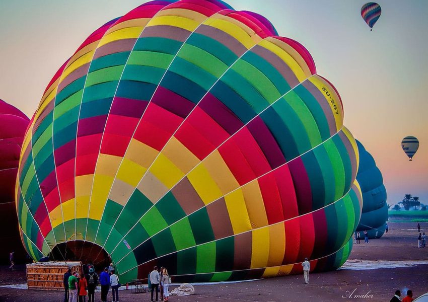 Colorful hot air balloons soaring over Luxor's ancient landscape at sunrise