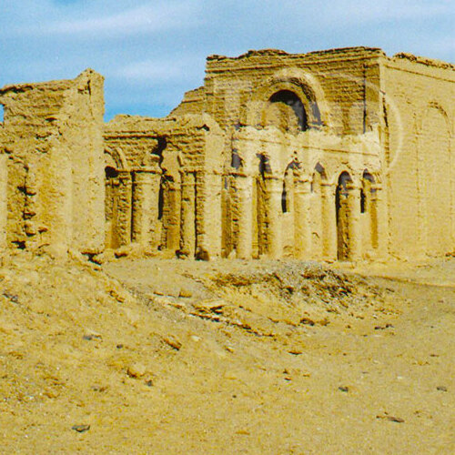 Ruins of mud brick walls and arches in a desert