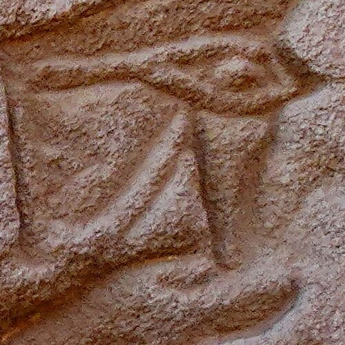 Close-up of an eye carved into stone with weathered textures