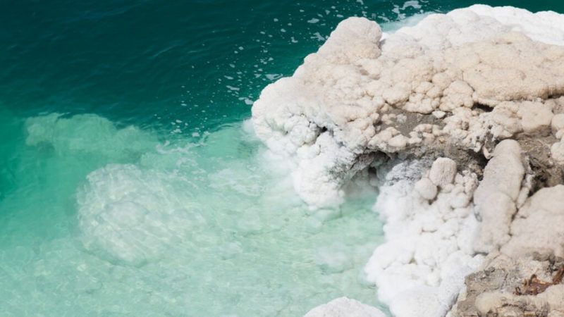 White salt deposits along the edge of turquoise water in a salt lake