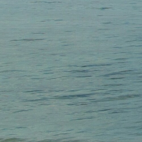 A serene expanse of blue water with gentle ripples