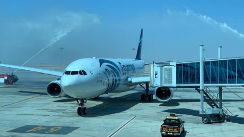 An airplane receiving a water cannon salute at the airport gate
