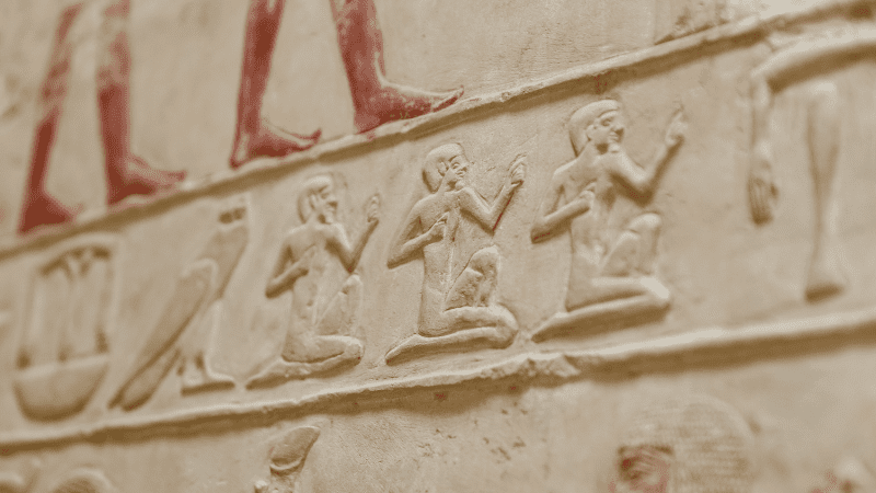 Close-up of ancient Egyptian hieroglyphs carved on a stone wall.