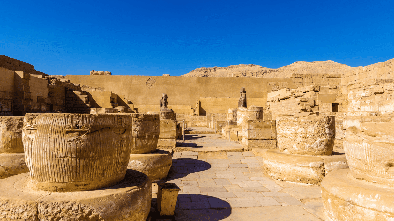 Ruins with ancient statues and columns in Egypt.