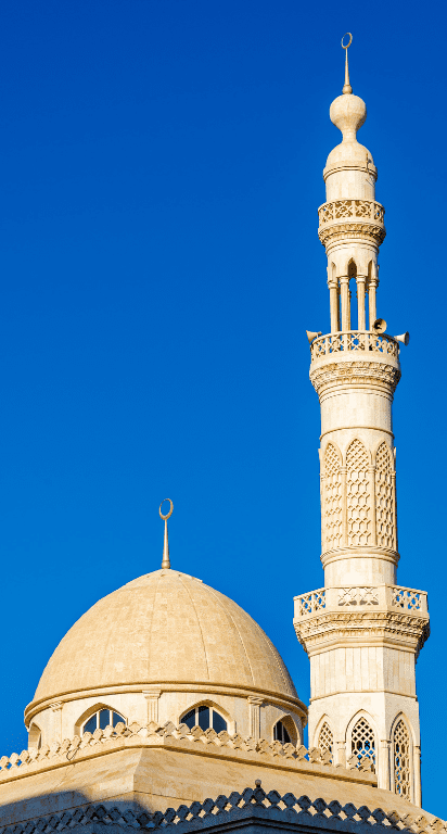 Historic mosque with intricate architecture and a prominent dome under a clear sky