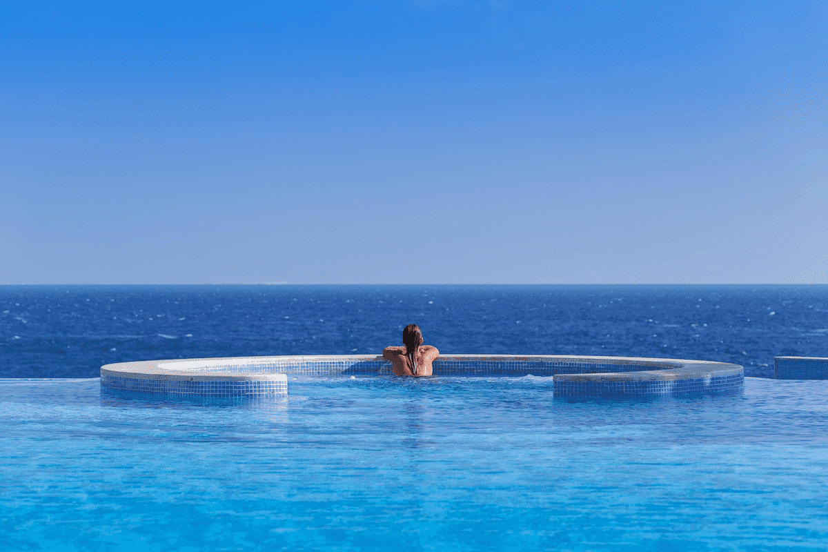 Luxurious beachfront view of The Oberoi Beach Resort, Sahl Hasheesh with clear turquoise waters and a golden sandy beach under a bright blue sky.